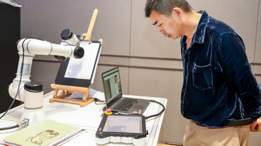 嘉賓體驗(yàn)遨博AI繪畫(huà)機(jī)器人。主辦方供圖